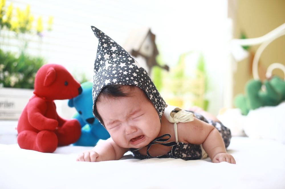 とんがり帽子をかぶった泣いてる赤ちゃん