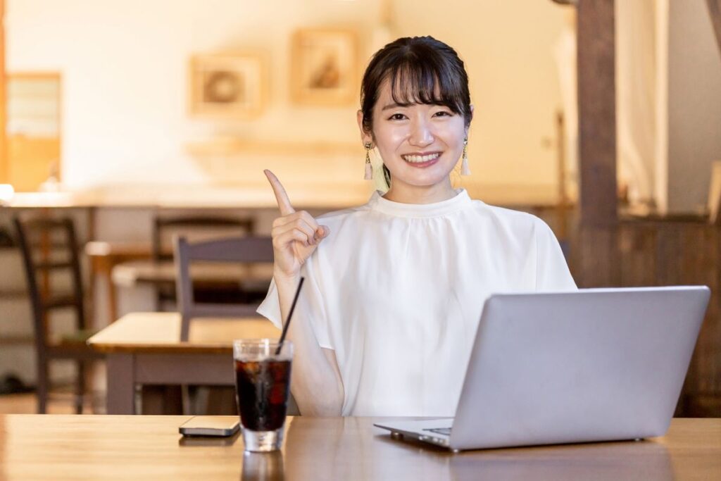 笑顔でカフェで仕事をする女性